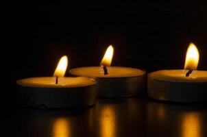 Candles shining in the dark representing religious prayer moment with customizable space for message, text or ideas. Religious and prayer concept photo