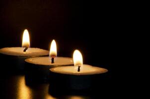Candles shining in the dark representing religious prayer moment with customizable space for message, text or ideas. photo