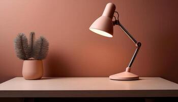 Modern desk setup with pink lamp and plant on wooden surface photo