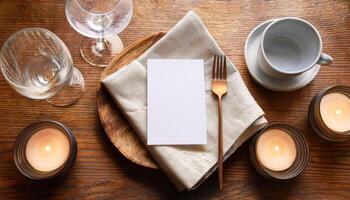 Elegant table setting with blank card, wine glasses, and candles on wooden surface photo