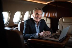 Handsome smiling businessman in suit looking at camera while sitting in private plane photo