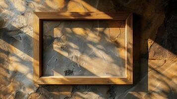 Empty Wooden Frame with Shadow on Textured Wall Surface photo