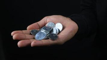 Close up of male hands holding Indonesian coins, savings and banking concept photo