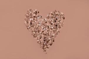 Elegant rose gold heart shaped from glittering sequins on soft background photo