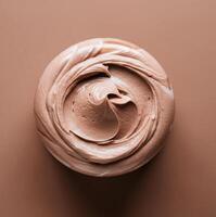 Top view of smooth brown swirled chocolate cream on circular surface photo