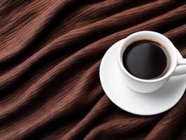 A cup of coffee on a saucer on a brown cloth photo