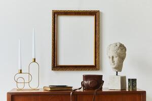 Stylish composition of artist workspace room with design retro teak commode, mock up poster frame, book, decoration and elegant accessories. Template. photo