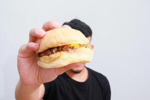 a close up image of an asian man holding hamburger isolated on white background photo