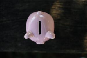 Pink piggy bank with a blessed one. concept of failure in saving and bad finances photo