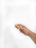 The image shows a hand holding a little round wooden bowl with a smooth surface. The plain white background emphasizes the natural texture and grain patterns of the wood, photo