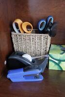 Desk organization basket with office tools and utensils. photo