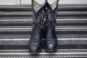 Pair of cowboy boots, on a door mat. photo