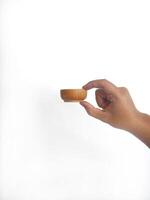 The image shows a pair of hands holding a round wooden bowl with a smooth surface. The plain white background emphasizes the natural texture and grain patterns of the wood, making the bowl central it photo