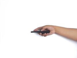 a hand holding a black remote control against a plain white background. The focus is on the remote, highlighting its buttons and ergonomic design. photo