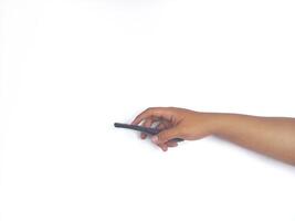 a hand holding a black remote control against a plain white background. The focus is on the remote, highlighting its buttons and ergonomic design. photo