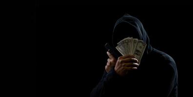 Portrait hacker spy man one person in black hoodie sitting on table looking computer laptop used login password attack security to data digital internet network system night dark background copy space photo