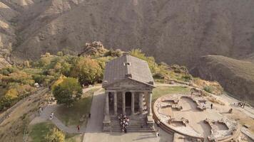 Garni, Armenia - 16th october, 2024 - aerial tilt down view visitors by The Garni Temple - classical colonnaded structure in the village of Garni. Pagan temple.Ancient greek roman style landmark video