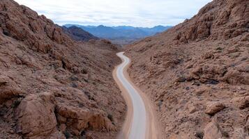Winding road through rocky mountains offers stunning view of nature photo
