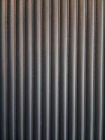 A photo of a background with a textured pattern of vertical lines in a dark neutral color.