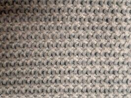 A photo of a textured knitted background in a neutral color.