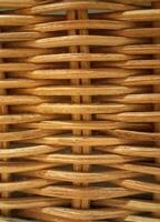 A photo of woven rattan in a neutral brown color, used as a textured abstract background.