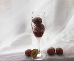 Three Moyer Plums in glass wine photo