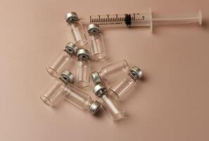 Syringe,vaccine bottles put on pastel background photo