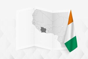 A grayscale map of Ivory Coast with a hanging Ivorian flag on one side. Map for many types of news. vector