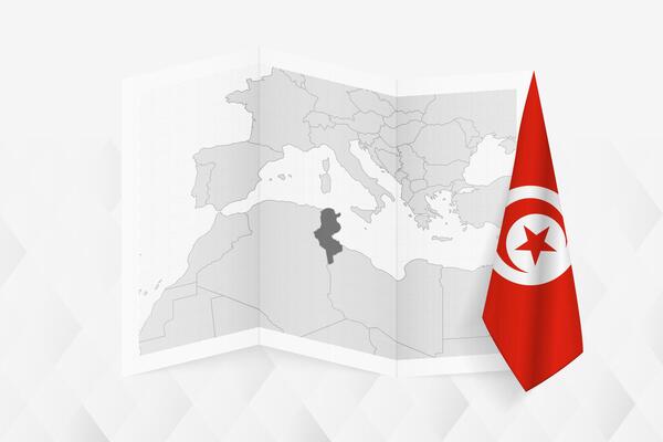 A grayscale map of Tunisia with a hanging Tunisian flag on one side. Map for many types of news.