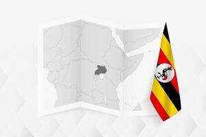 A grayscale map of Uganda with a hanging Ugandan flag on one side. Map for many types of news. vector