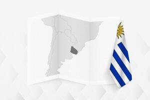 A grayscale map of Uruguay with a hanging Uruguayan flag on one side. Map for many types of news. vector