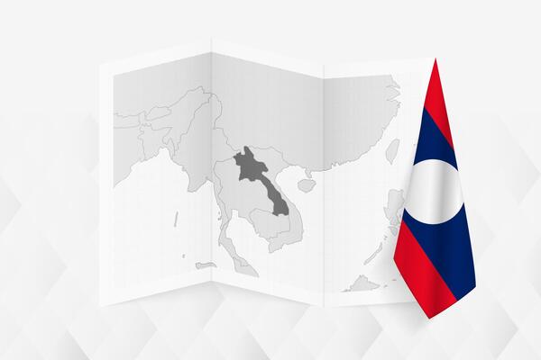 A grayscale map of Laos with a hanging Laotian flag on one side. Map for many types of news.