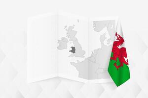 A grayscale map of Wales with a hanging Wales flag on one side. Map for many types of news. vector