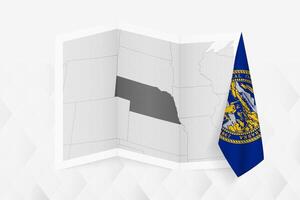 A grayscale map of Nebraska with a hanging Nebraska flag on one side. Map for many types of news. vector