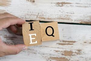 Business man hand change wooden cube block from IQ to EQ, balance between intelligence quotient photo