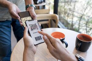 Customer scanning QR code, making a quick and easy contactless payment with smartphone in a cafe. photo