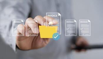E-invoice and online digital statements concept. Businessman using computer laptop with invoice icons on virtual screen. photo