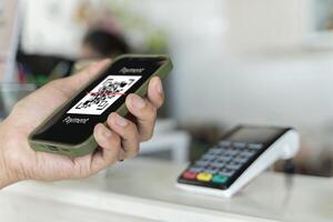 Focus on Scan here to pay text, Close up of hands Scaning QR code for digital contact less payment after shopping photo