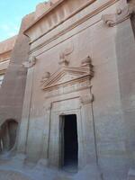 A beautiful view of the caves built into the mountains at the archaeological site of Hegra in Madain Saleh, AlUla in Saudi Arabia. photo