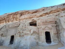 A beautiful view of the caves built into the mountains at the archaeological site of Hegra in Madain Saleh, AlUla in Saudi Arabia. photo