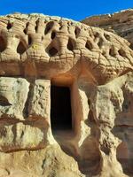 A beautiful view of the caves built into the mountains at the archaeological site of Hegra in Madain Saleh, AlUla in Saudi Arabia. photo