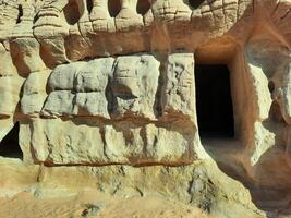 A beautiful view of the caves built into the mountains at the archaeological site of Hegra in Madain Saleh, AlUla in Saudi Arabia. photo