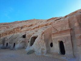A beautiful view of the caves built into the mountains at the archaeological site of Hegra in Madain Saleh, AlUla in Saudi Arabia. photo