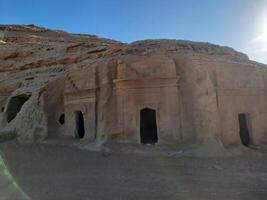 A beautiful view of the caves built into the mountains at the archaeological site of Hegra in Madain Saleh, AlUla in Saudi Arabia. photo