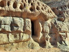 A beautiful view of the caves built into the mountains at the archaeological site of Hegra in Madain Saleh, AlUla in Saudi Arabia. photo
