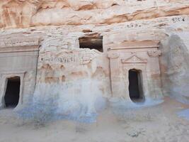 A beautiful view of the caves built into the mountains at the archaeological site of Hegra in Madain Saleh, AlUla in Saudi Arabia. photo