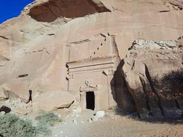 A beautiful view of the caves built into the mountains at the archaeological site of Hegra in Madain Saleh, AlUla in Saudi Arabia. photo
