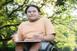 Young Artist in Wheelchair Enjoying Creative Outdoor Session with Coffee in Lush Green Park Setting photo