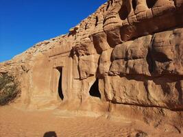 A beautiful view of the caves built into the mountains at the archaeological site of Hegra in Madain Saleh, AlUla in Saudi Arabia. photo