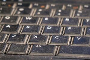 Dusty keyboard on a used laptop showing wear and tear during everyday tasks photo